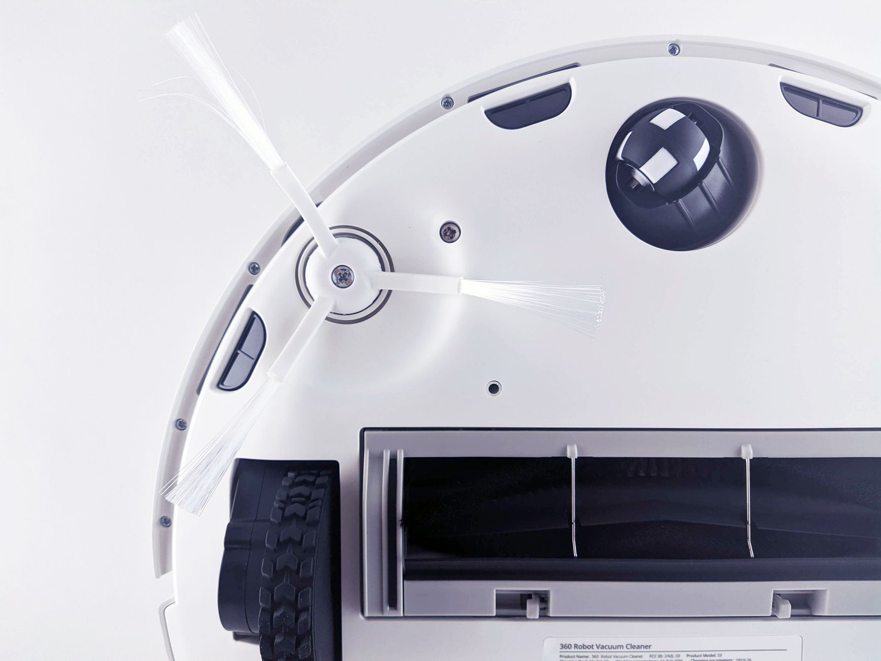 Close-up view of robot vacuum roller cleaning rug bristles efficiently